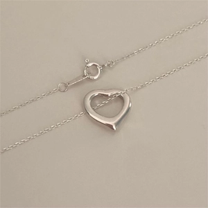 Macro detail of 925 sterling silver heart necklace clasp showing hallmark and chain