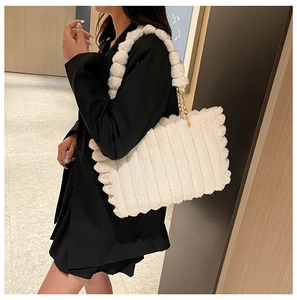 Detail of white plush tote bag with striped texture, metal chain, and soft faux fur strap