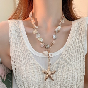 Macro detail of Y-shaped beaded necklace with starfish and seashell charms on a model