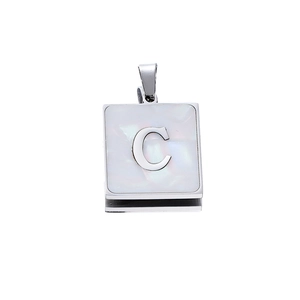 Detail of a square stainless steel pendant with white shell inlay and letter C