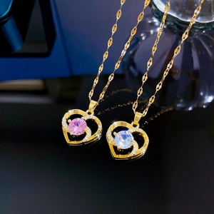 Macro detail of luxury heart pendants with pink and white cubic zirconia on black surface