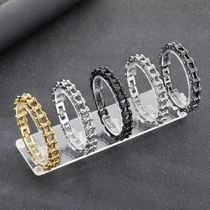Detail view of bicycle chain bracelets in gold silver and black on acrylic display stand