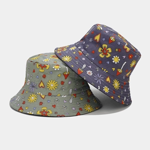 Close-up of mushroom and floral prints on cotton bucket hats in olive and navy