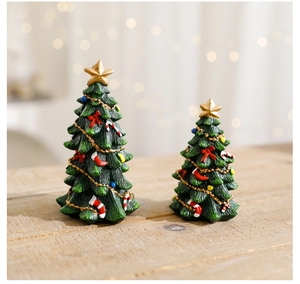 Macro detail of miniature resin Christmas trees with gold star and festive ornaments