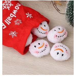 Close-up of plush white snowballs with smiley faces spilling from a red drawstring bag