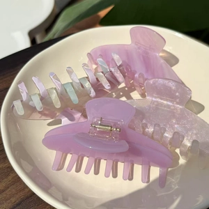 Close-up of three large purple acetate hair claws in glossy and marble finishes