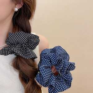 Detailed shot of double-layer polka dot hair scrunchies in black and blue fabric