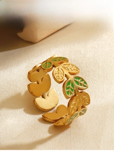 Macro view of adjustable gold-tone leaf ring with green enamel inlay details