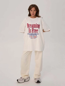 Dettaglio della t-shirt oversize color crema con stampa e dei pantaloni larghi abbinati
