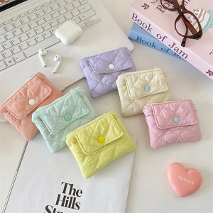 Detailed view of quilted macaron-colored coin purses with snap buttons and zippers
