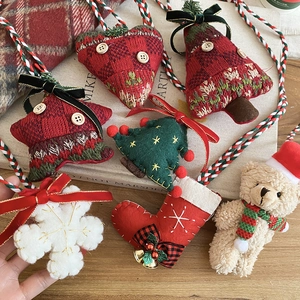 Detailed close-up of knitted Christmas ornaments featuring felt stars, trees and teddy bears