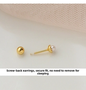 Detailed close-up of a gold pearl screw-back earring against soft pink tulle background