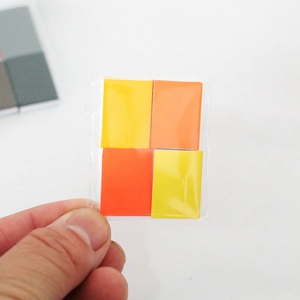 Close-up of yellow and orange miniature dollhouse books in clear plastic packaging