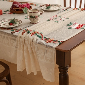 Detail of Christmas table runner with embroidered red bells and green holly leaves