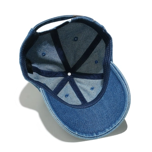 Detail view of denim baseball cap interior showing 100% cotton label and stitching