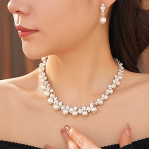 Elegant pearl and diamond necklace set worn by a model in a luxury indoor setting