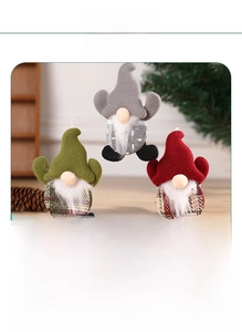 Detail showing plush Christmas gnome ornaments in grey, green, and red with knit hats