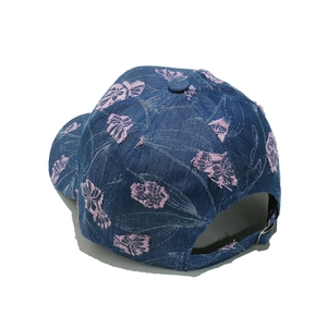 Detailed close-up of blue denim baseball cap with pink floral embroidery and metal buckle