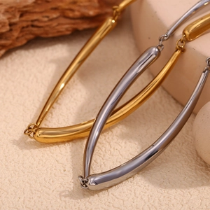 Polished 18K gold and silver V-shaped bamboo pendant necklaces on stone display