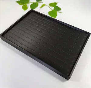 Macro view of matte black 100-slot jewelry display tray for rings and earrings