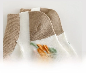 Detail of reinforced sock heel with striped knit pattern and orange floral embroidery
