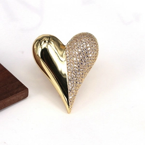 Macro view of gold-plated heart ring with asymmetric cubic zirconia pavé detailing