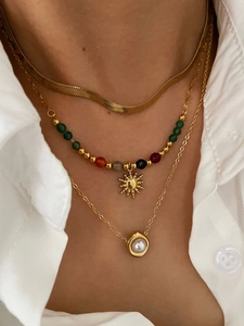 Detailed layered necklace set featuring a sunburst pendant and a white pearl charm