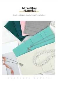 Detail of microfiber jewelry pouches in various colors on marble surface with pearls
