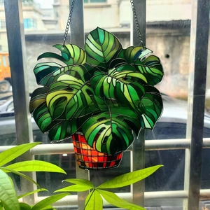 Hanging acrylic monstera plant suncatcher with green leaves and a metal chain for windows
