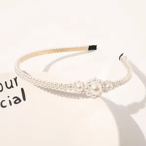 Detail of elegant pearl cluster flower on thin gold metal headband for women