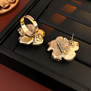 Detailed view of the gold flower jewelry back showing the DREJEW brand logo engraving