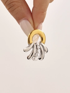 Detail shot of two-tone metal earrings with flowing lines and elegant white pearls