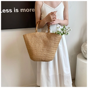 Detailed close-up of handmade straw tote bag with bamboo handles and summer daisy decor