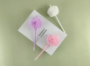 Détail de stylos licorne créatifs avec pompons en peluche en violet, rose et blanc