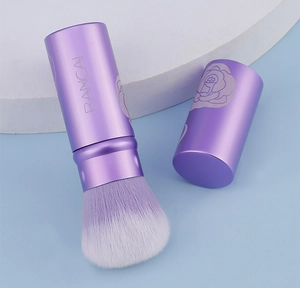 Dettaglio del pennello da trucco retrattile con motivi di rose viola e setole morbide sfumate