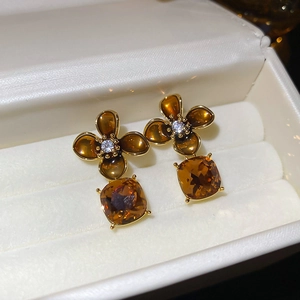 Macro shot of 18K gold-plated floral earrings with amber stones and zircon accents