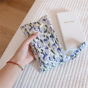 Detailed view of mini floral cotton pouch with wrinkled texture and blue-purple pattern