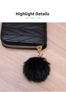 Detail of black quilted leather wallet with V-stitch pattern and gold pom-pom zipper