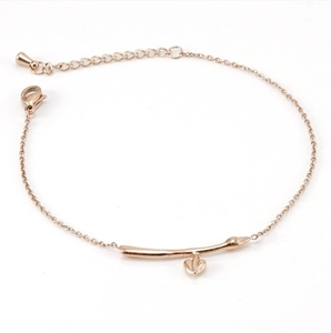 Détail d'un bracelet branche en or rose avec pendentifs feuilles et fermoir ajustable