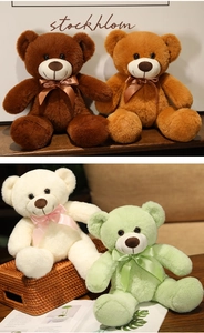 Close-up of colorful teddy bears with silk bows in dark brown, tan, cream, and green