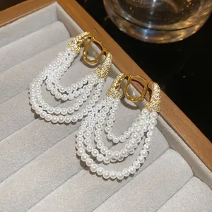 Élégantes boucles d'oreilles dorées avec glands en perles et pendentifs en zircon chic