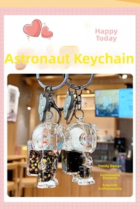 Close-up of black and gold astronaut liquid quicksand keychains with star glitter