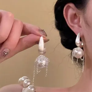 Elegant matte metal pearl drop earrings with sparkling rhinestone tassel detail