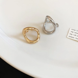 Detailed macro view of polished gold and silver organic liquid metal open rings