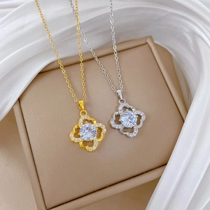 Close-up of sparkling four-leaf clover pendant with zircon inlay on luxury silk fabric