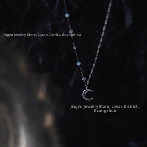 Detailed view of silver moon crescent pendant with clear beads on a titanium chain