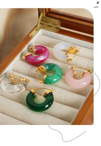 Detailed set of six colorful C-shaped resin earrings arranged in a velvet jewelry box