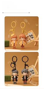 Detail view of cute PVC cartoon couple keychain with stylish school-style outfits and hooks