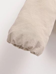 Detail der elastischen Bündchen und des dichten Gewebes der beigen Winter-Pufferjacke