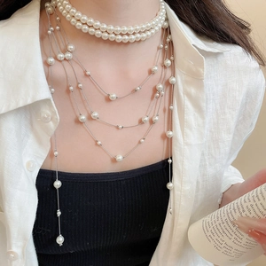 Detail of elegant multi-layer pearl fringe necklace worn with a stylish outfit